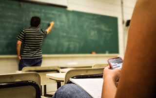 Man in black and white polo shirt beside writing board