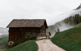 Wooden house next to road in mountain valley